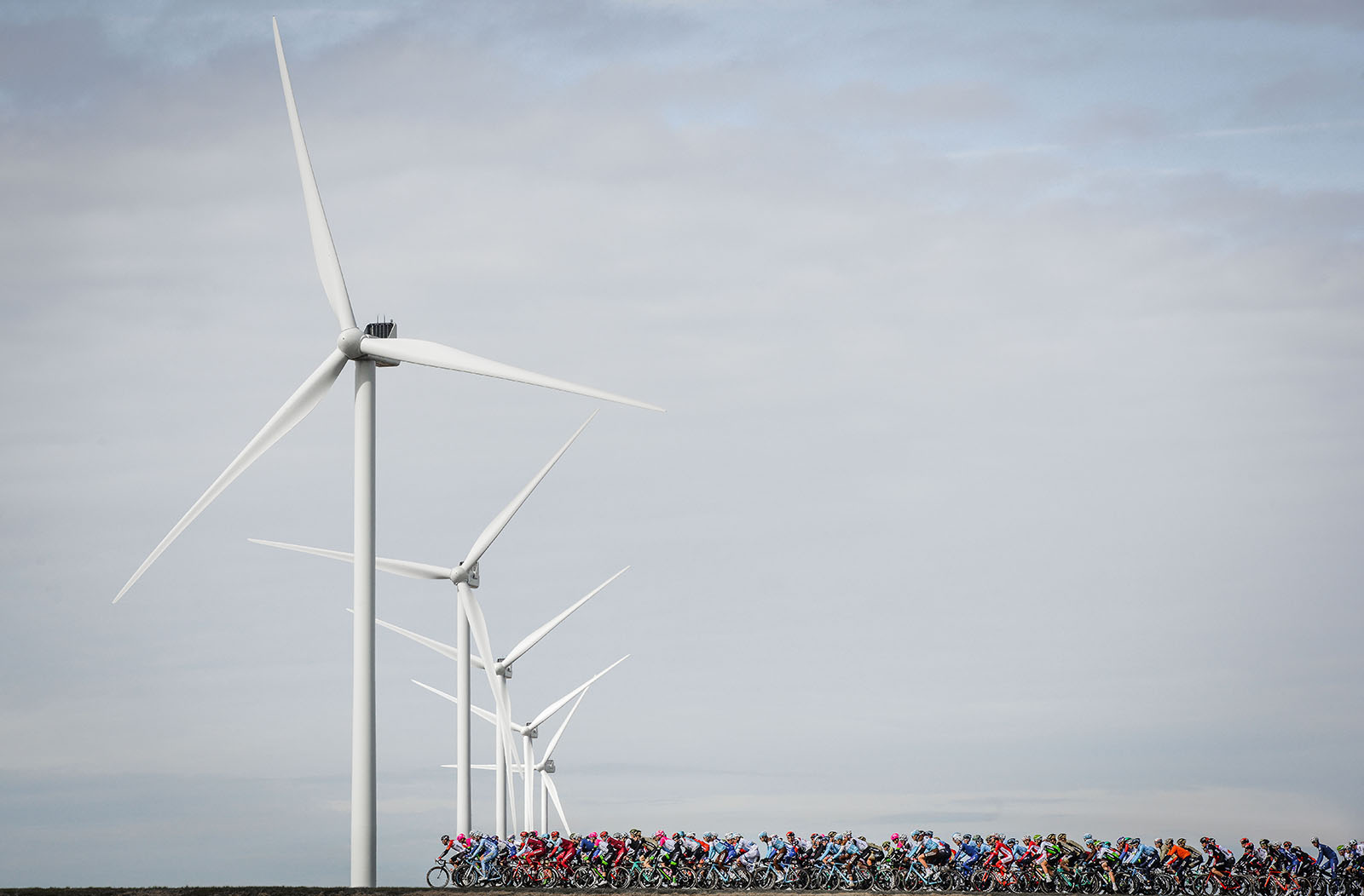 The Peleton passing some Windmills in Paris-Nice Cycling race