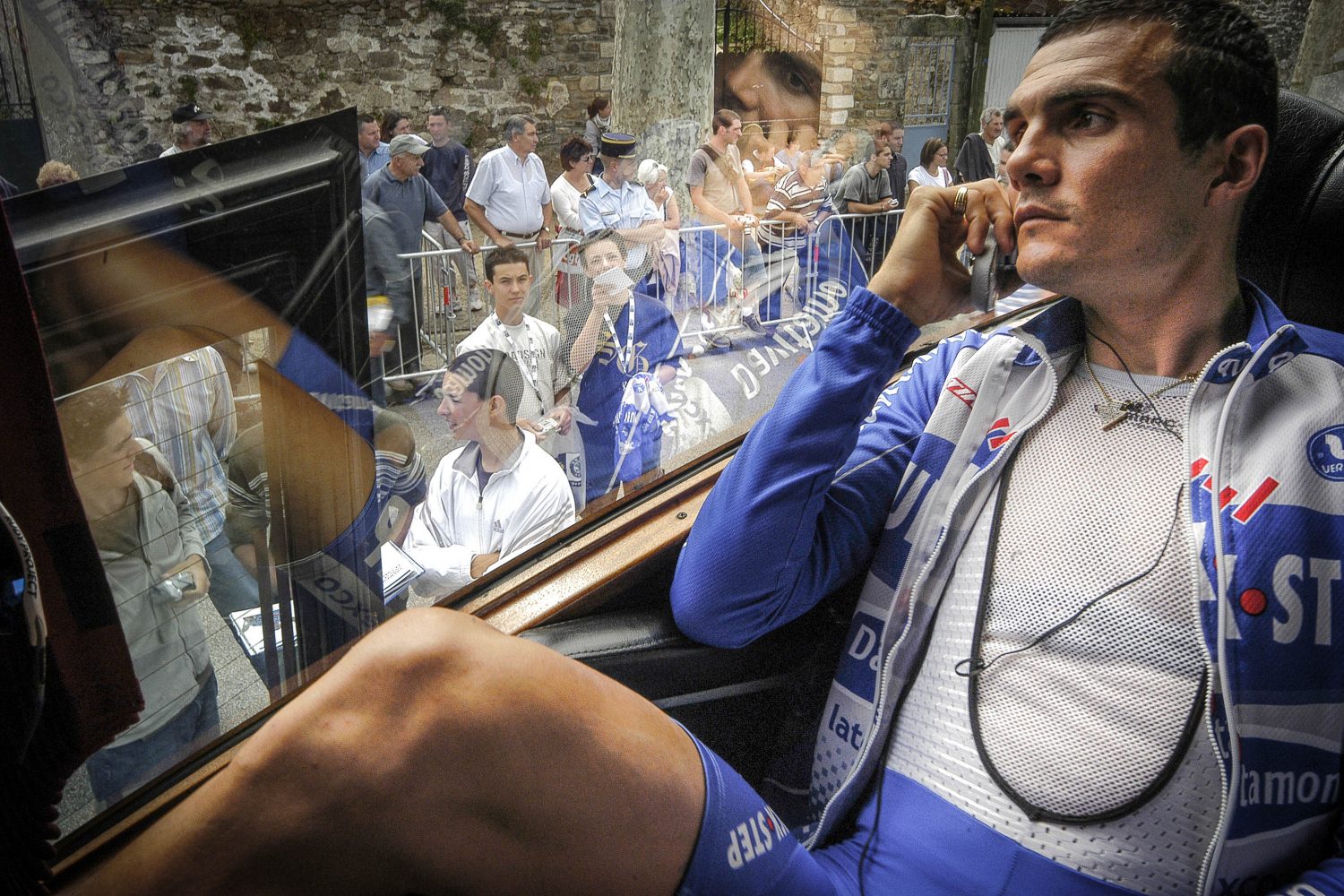 Virenque sitting in the bus speaking in his mobile phone and look at the crowd